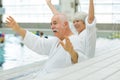 excited elderlies on bathrobe next to swimming pool