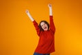 Excited emotional happy young pretty woman posing isolated over yellow wall background