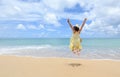 Excited energetic happy tourist girl is jumping at the beach on summer vacations, fun and freedom