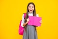 Excited face. Schoolgirl, teenage student girl hold book on yellow isolated studio background. School and education Royalty Free Stock Photo