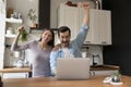 Excited young couple cheering for football team online at kitchen Royalty Free Stock Photo