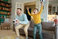 Excited father and son cheering and watching football match at home Royalty Free Stock Photo