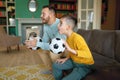 Excited father and son cheering and watching football match at home Royalty Free Stock Photo