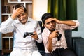 Excited father and son got sad while playing video game using gamepad due loss - concept of entertainment, weekend Royalty Free Stock Photo