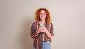 Excited female entrepreneur with curly hair using social media on smart phone over white background Royalty Free Stock Photo