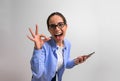 Excited female entrepreneur screaming ecstatically and showing OK hand sign after reading good news over smart phone. Portrait of