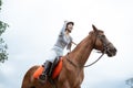 Excited female equestrian while riding horse holding reins
