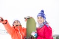 Excited female friends with snowboard outdoors Royalty Free Stock Photo