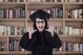 Excited female graduate shouting at library Royalty Free Stock Photo