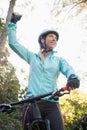 Excited female mountain biker in forest Royalty Free Stock Photo