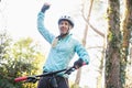 Excited female mountain biker in forest Royalty Free Stock Photo