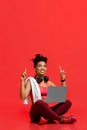 Excited fitness girl with laptop pointing up at copy space