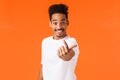 Excited friendly, smiling and happy african american hipster guy, male model luring someone, stretching hand and waving Royalty Free Stock Photo