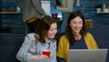 Excited friends watching entertainment show on laptop while sitting on couch Royalty Free Stock Photo