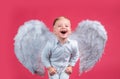 Excited funny angel children boy with white wings laughing. Valentines day cupid child.