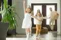 Excited funny kids running inside new house on moving day