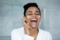 Excited funny woman in white bathrobe enjoying home beauty care