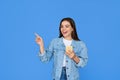 Excited gen z Latin girl using smartphone pointing isolated on background. Royalty Free Stock Photo