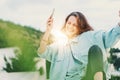 Excited girl dancing and listening music with headphones and smart phone in the street at sunset Royalty Free Stock Photo