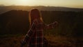 Excited girl dancing in mountains at sunset. Woman turning around in meadow Royalty Free Stock Photo