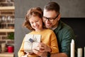 Excited girl daughter receiving gift box from young loving father on holiday