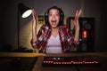 Excited girl gamer sitting at the table, playing online games