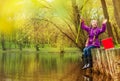 Excited girl holding fishrod out of the water