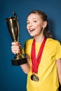 Excited girl with medals and trophy cup