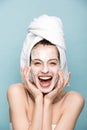 Excited girl with moisturizing facial mask laughing at camera