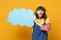 Excited girl teenager in french beret, denim sundress hold blue empty blank Say cloud, speech bubble isolated on yellow Royalty Free Stock Photo