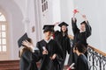 Excited graduate pointing at diploma near