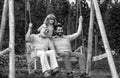 Excited grandfather father and son playing outdoors, sitting on the swing. Happy men family. Three men generation. Royalty Free Stock Photo