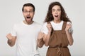 Excited guy and stunned curly woman looking surprisingly at camera. Royalty Free Stock Photo