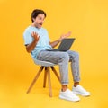 Excited guy using laptop celebrating success sitting on chair Royalty Free Stock Photo