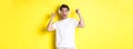 Excited handsome man dancing and singing along, listening music in headphones, standing over yellow background Royalty Free Stock Photo