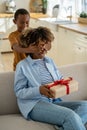 Excited happy African American woman mother receiving mothers day gift from child Royalty Free Stock Photo