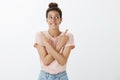 Excited and happy attractive woman with hairbun in t-shirt biting lower lip in anticipation and interest making choice