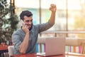 Excited happy bearded freelancer reading email with results about victory in modern online contest sitting at laptop