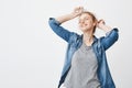 Excited happy caucasian redhead girl dancing with raised hands while listening music via headphones, holding smartphone Royalty Free Stock Photo