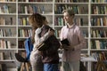 Excited happy college students hugging in public library Royalty Free Stock Photo