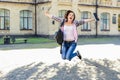 Excited happy joyful female student jumping with book in her han Royalty Free Stock Photo