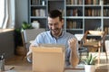 Excited happy man looking into cardboard box, receive parcel