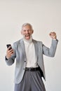 Excited happy old business man investor raising fist using mobile phone.