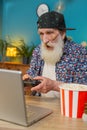 Excited happy senior man celebrating victory in play video game on laptop using controller joystick Royalty Free Stock Photo