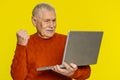 Excited happy senior man working on laptop winning lottery game, celebrating success, victory Royalty Free Stock Photo