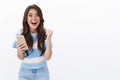 Excited happy triumphing woman hold smartphone, fist pump and smiling enthusiastic, receive great fantastic news via