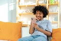 Excited happy young black african american woman holding cell phone laughing feeling joy getting mobile message Royalty Free Stock Photo