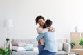 Excited happy young black couple celebrating buying new home, husband lifting wife, in moving day Royalty Free Stock Photo