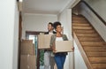 Excited, happy and young couple moving into a new home together while carrying and packing household boxes. Smiling Royalty Free Stock Photo