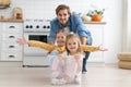 Excited happy young father run push cardboard box with little cute children daughters ride inside, having fun.